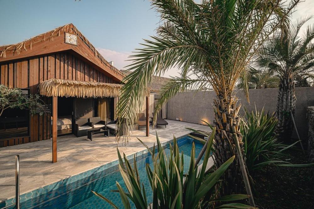 eine Villa mit Swimmingpool und ein Haus in der Unterkunft Jeju Sentosa Hallim in Jeju-do