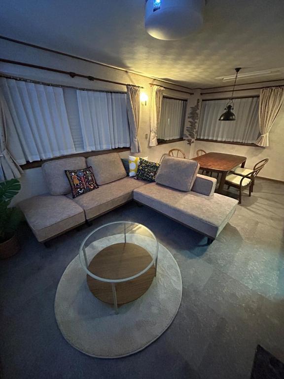 a living room with a couch and a table at T'S House Numazu in Numazu