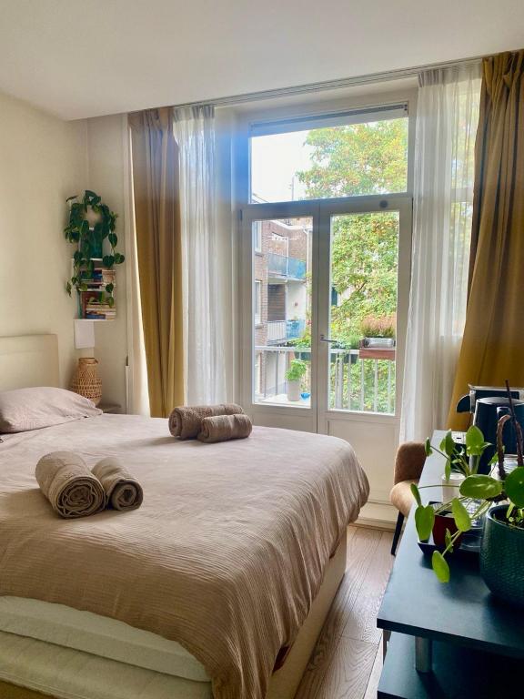 a bedroom with a large bed and a large window at Spacious Room with private king bathroom in Amsterdam