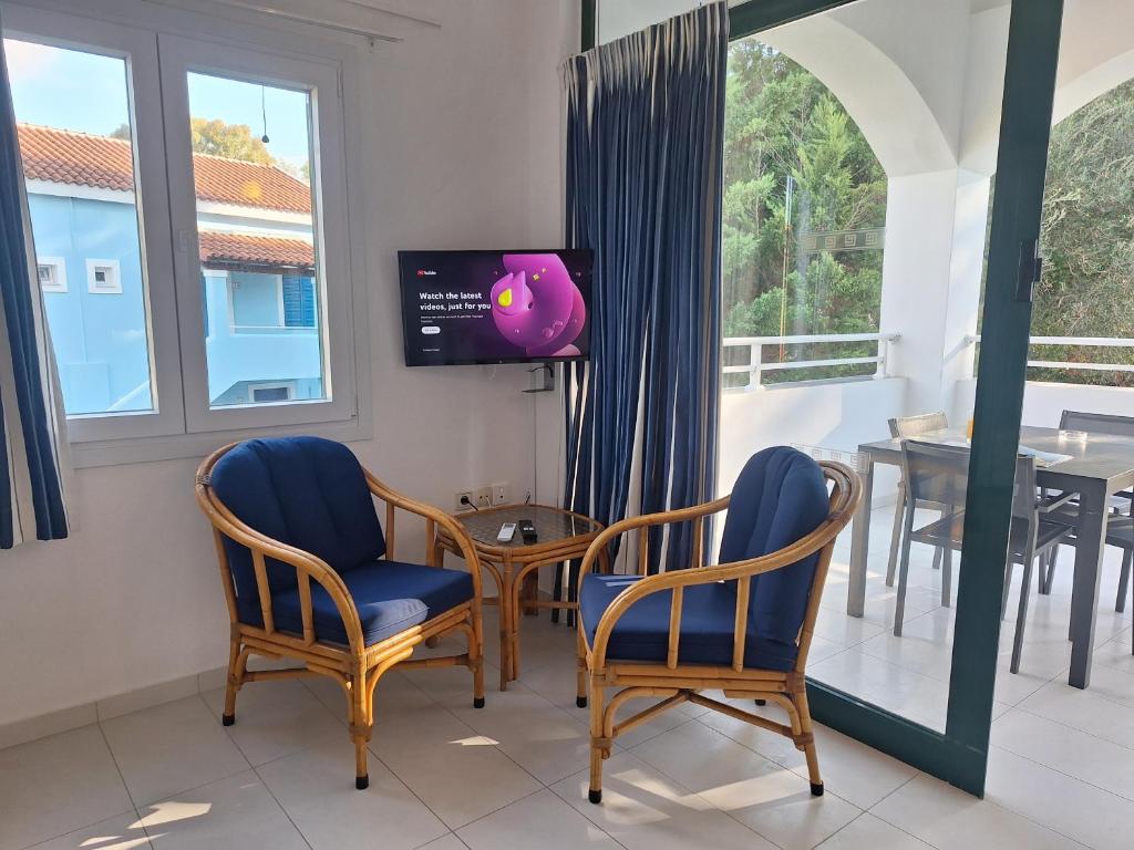 un soggiorno con 2 sedie e una TV di Helion Resort a Gouviá