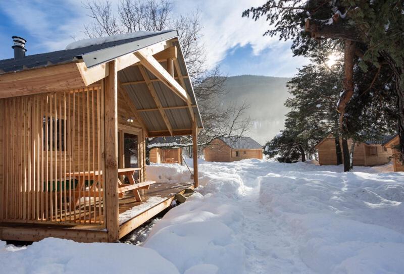 a small wooden cabin in the snow at Huttopia Bourg St Maurice in Bourg-Saint-Maurice