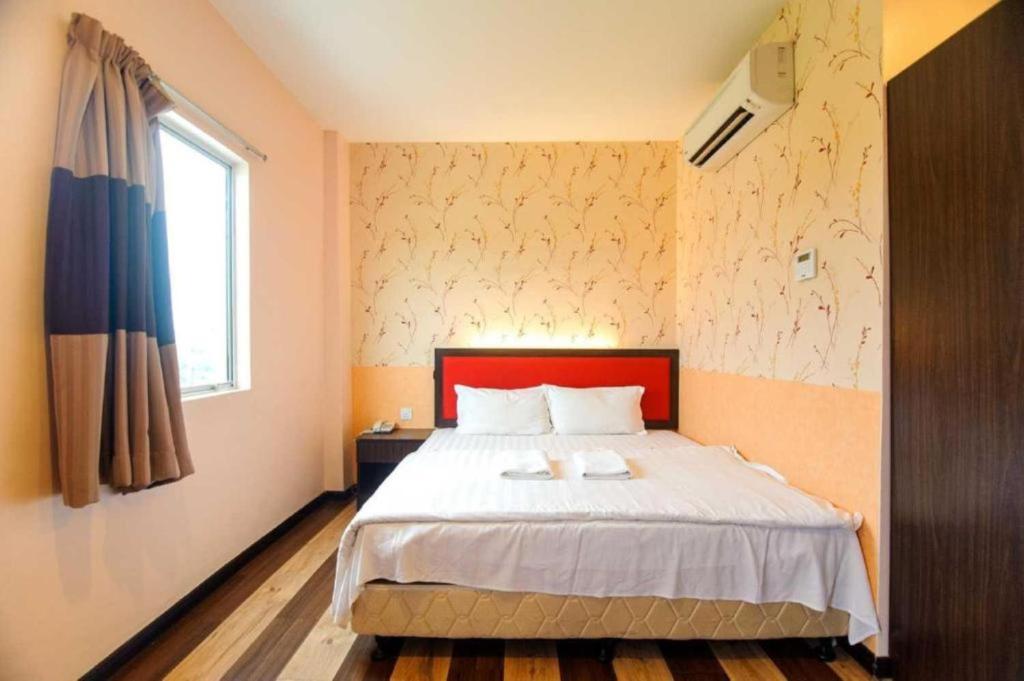 a bedroom with a bed with a red headboard and a window at Swing & Pillows - Sky Star, KLIA 1 KLIA 2, Sepang in Sepang