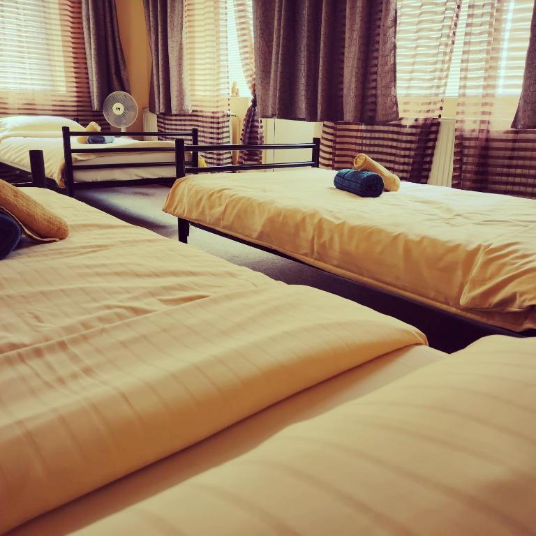 two beds sitting next to each other in a bedroom at Clara Family Room in Cluj-Napoca