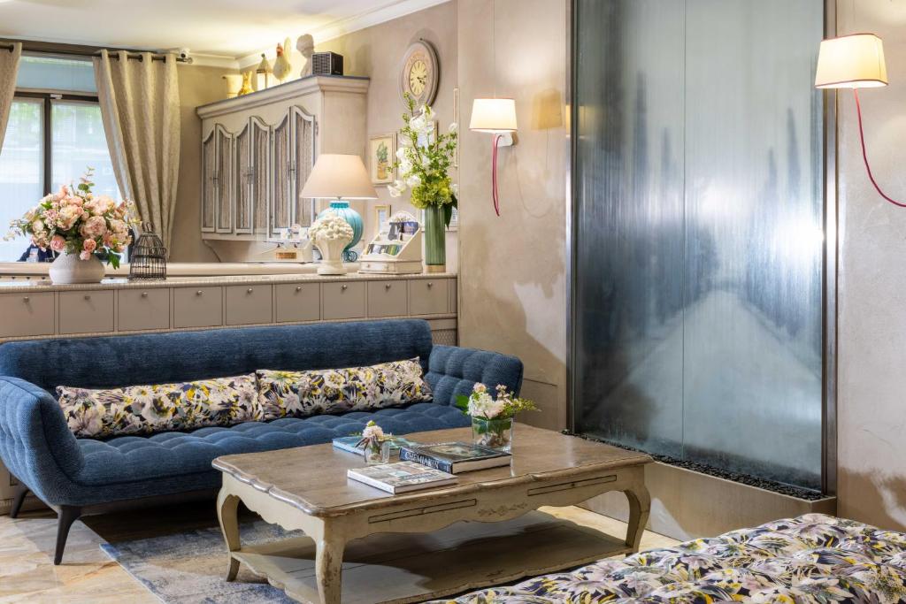 a living room with a blue couch and a coffee table at Hotel Daumesnil-Vincennes in Vincennes