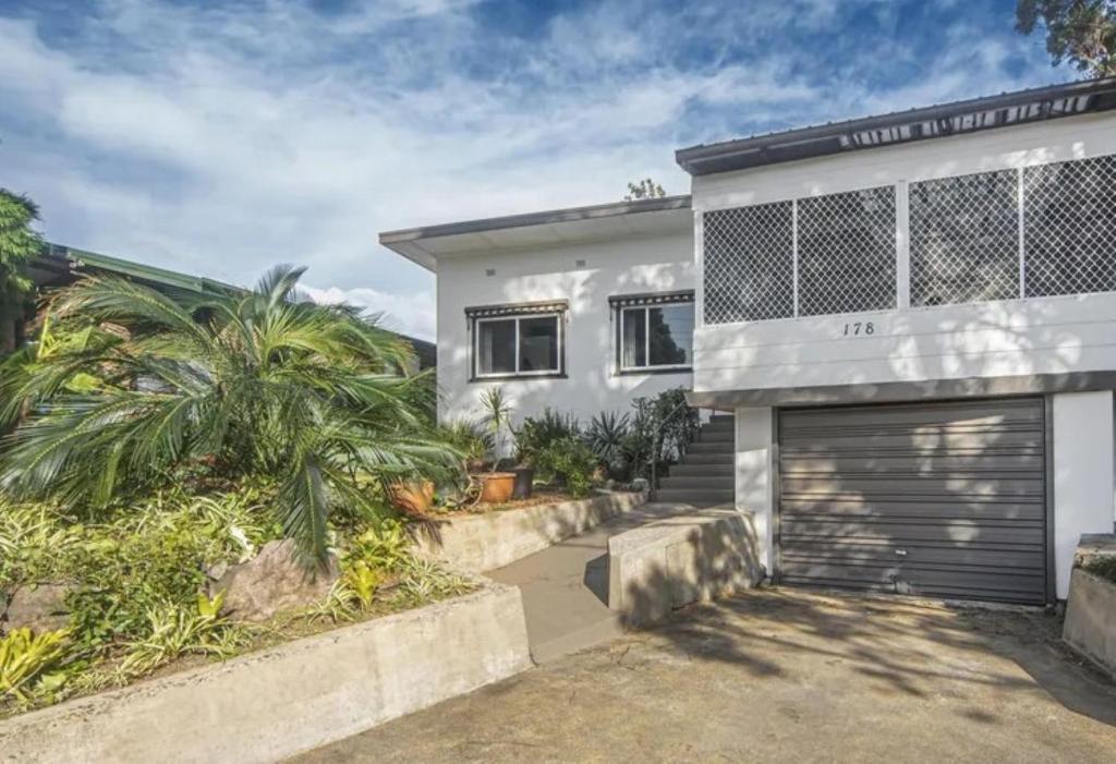 a white house with a garage at The Waratah Escape Nowra in Nowra
