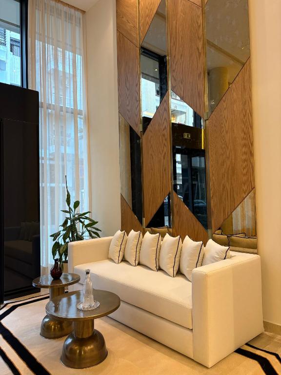 ein Wohnzimmer mit einem weißen Sofa und einem Fernseher in der Unterkunft Dally Apart Hotel in Rabat