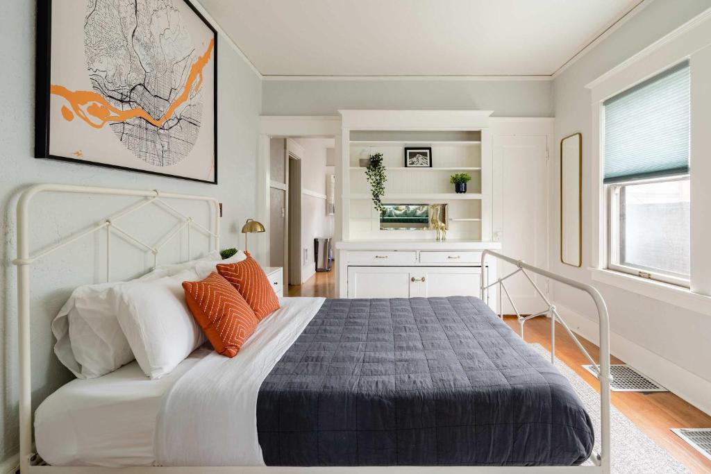 une chambre avec un lit avec des oreillers orange dans l'établissement Stay Portland - PDX Art Deco Lounge - Local Eateries, Bars & Shops, à Portland