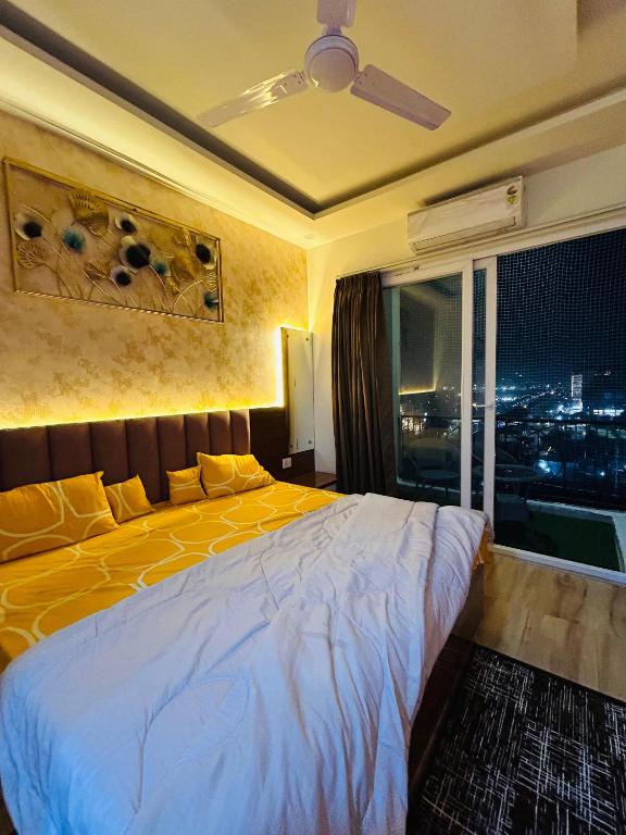 1 dormitorio con cama amarilla y ventana en Ghar - near expo mart -cozy stay away from home, en Greater Noida