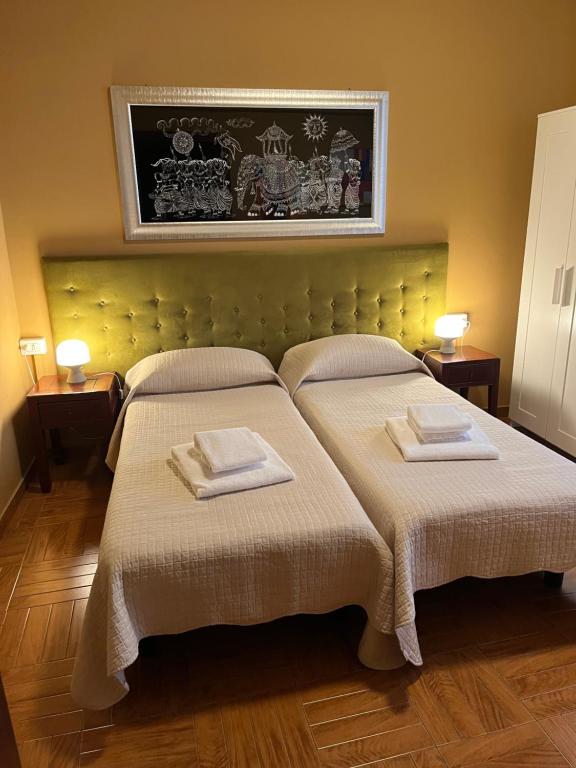 una camera da letto con due letti con asciugamani sopra di Corso Porta Nuova 39 a Verona