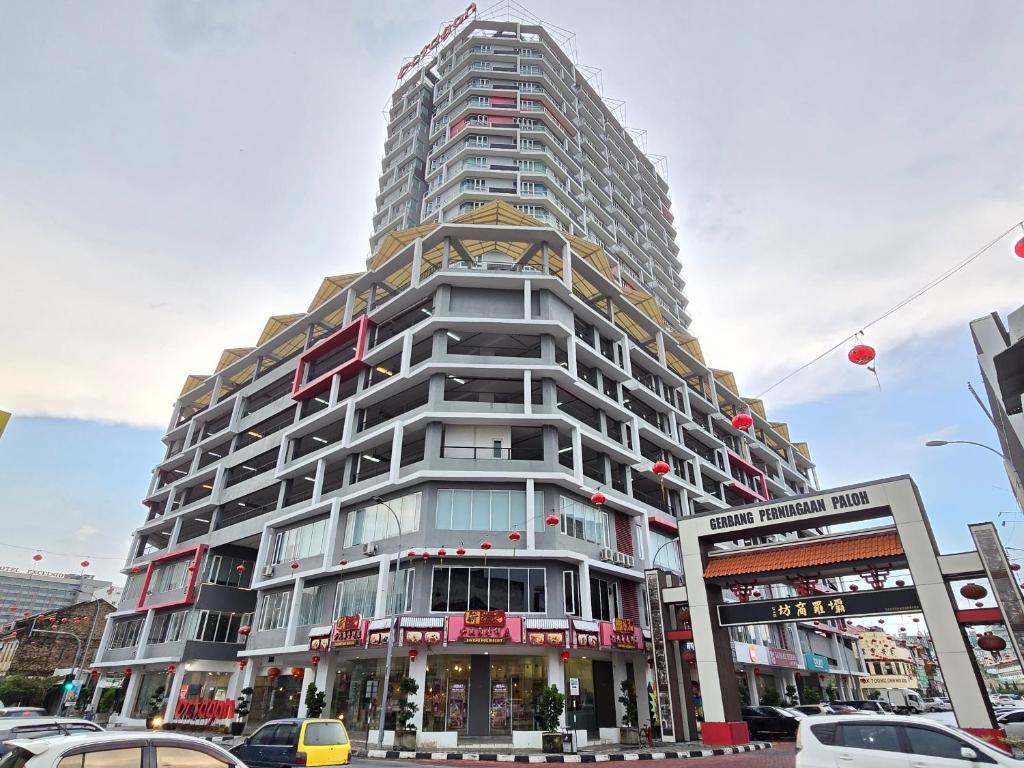 Un edificio alto en una calle de la ciudad con coches. en The Octagon -The City Centre Signature Suite in Ipoh, en Ipoh