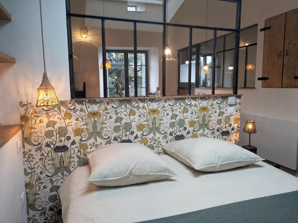 a large bed with two pillows in a bedroom at La Fusterie in Les Vans