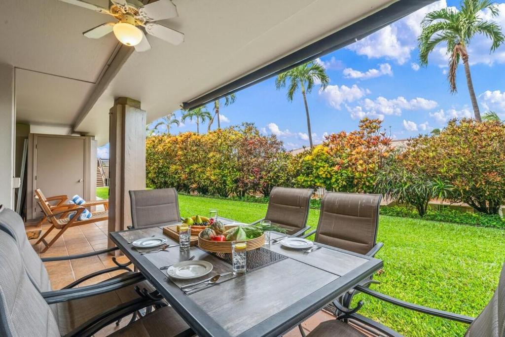 a table with a bowl of fruit on a patio at Eldorado L102 · EL L102 Renovated 1BD Condo w Pool AC Beach Caba in Kahana