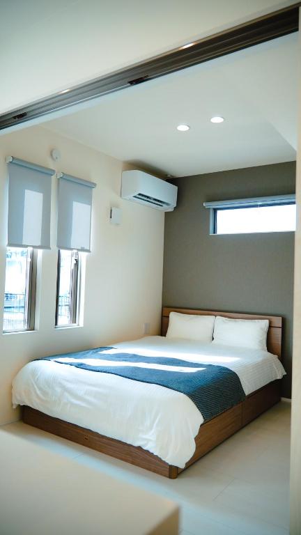 a bedroom with a large bed with two windows at Opt熊本益城 in Mashiki