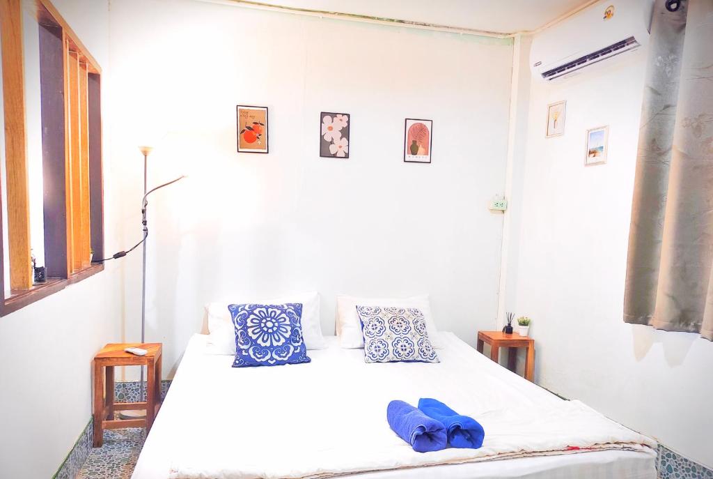 a bedroom with a white bed with blue pillows at house 1 for 6 paxs whole house 3 beds in Hat Yai