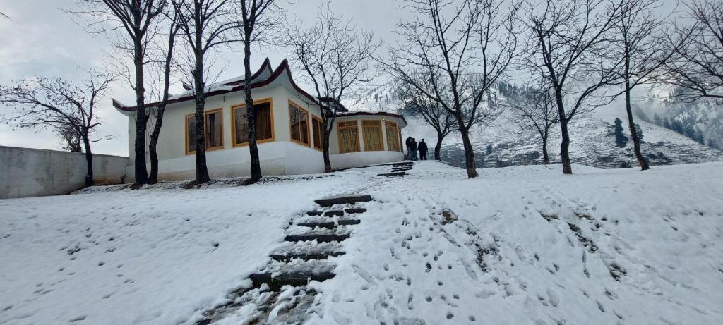 a building in the snow with people standing in it at Riverside Challets Sharda in Shardi