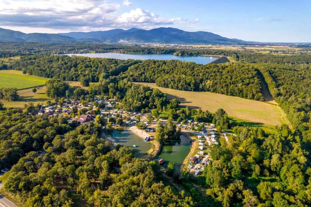an aerial view of a village on a river and trees at Camping Alsace Les Castors in Burnhaupt-le-Haut