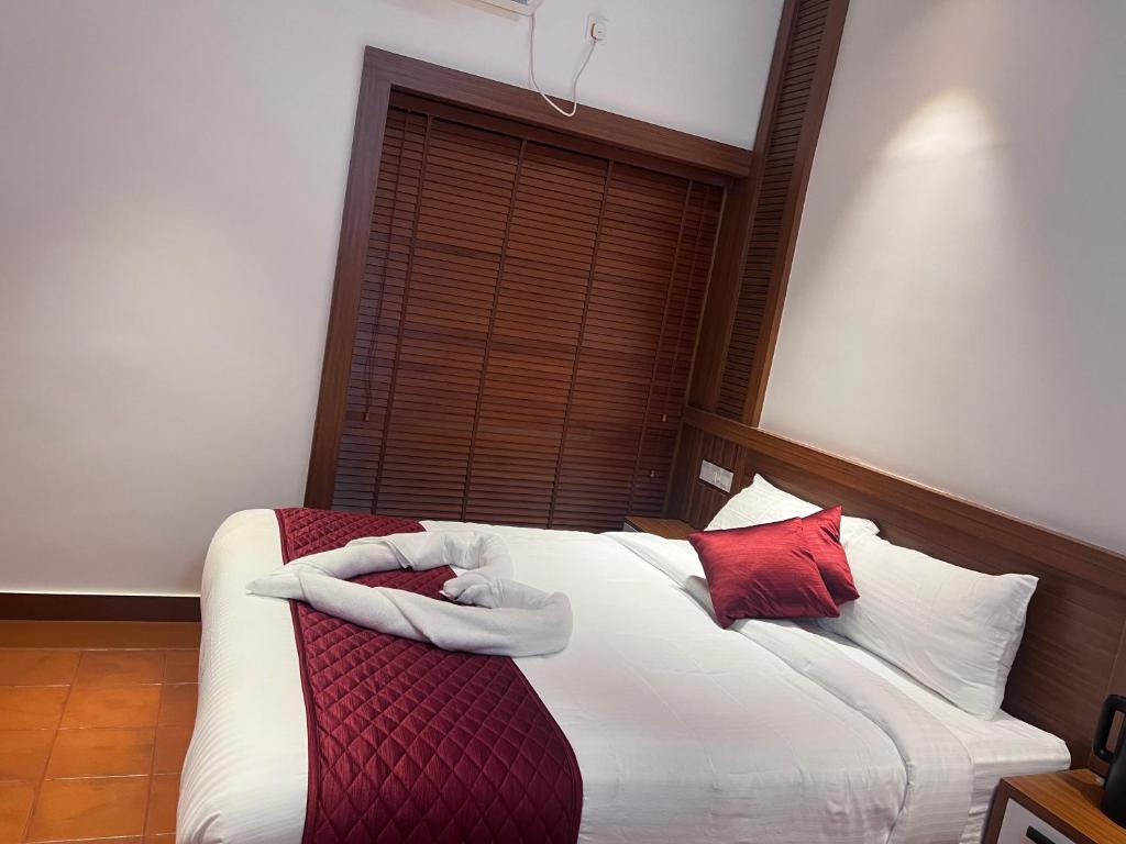 Un dormitorio con una cama con almohadas rojas y blancas. en Haveninn, en Kallana