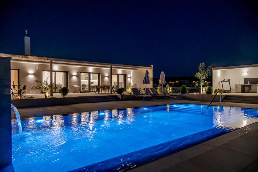 a swimming pool in front of a house at night at Villa La Caretta in Alikanas