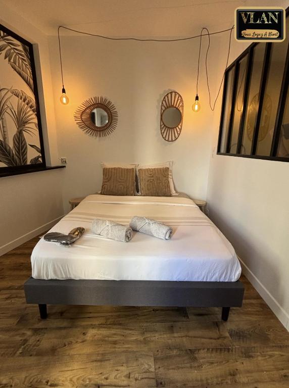 a bedroom with a bed with white sheets at A l'angle du vieux marché in Niort