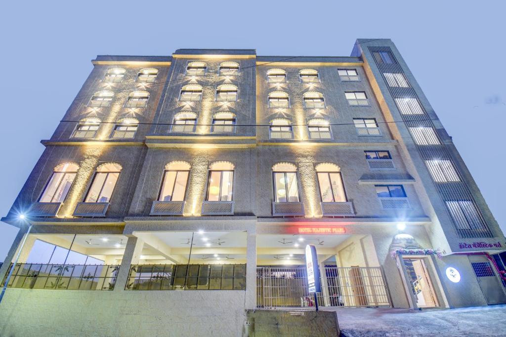 ein hohes Gebäude mit eingeschaltetem Licht in der Unterkunft Hotel Majestic Pearl in Nashik