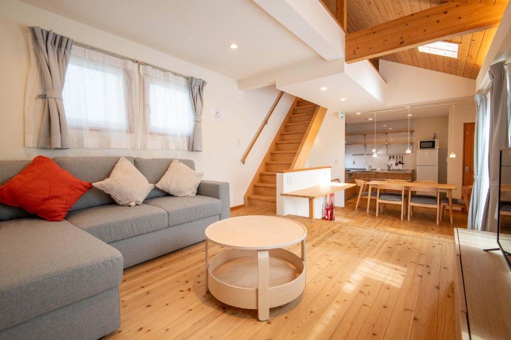ein Wohnzimmer mit Sofa und Tisch in der Unterkunft Muku House Urayasu in Tokio