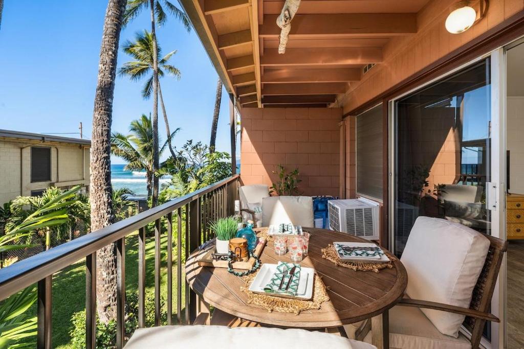 a table on a balcony with a view of the ocean at Maui Sands Seaside 713 · MSS 713 Charming 1BD Near Beach in Kahana