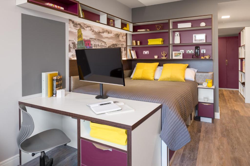 a bedroom with a bed and a desk with a computer at The Ascent in Liverpool