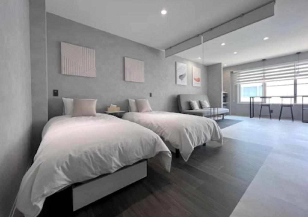 a bedroom with two beds and a living room at Jasmin Nishikimachi IV - Vacation STAY 13089v in Takamatsu