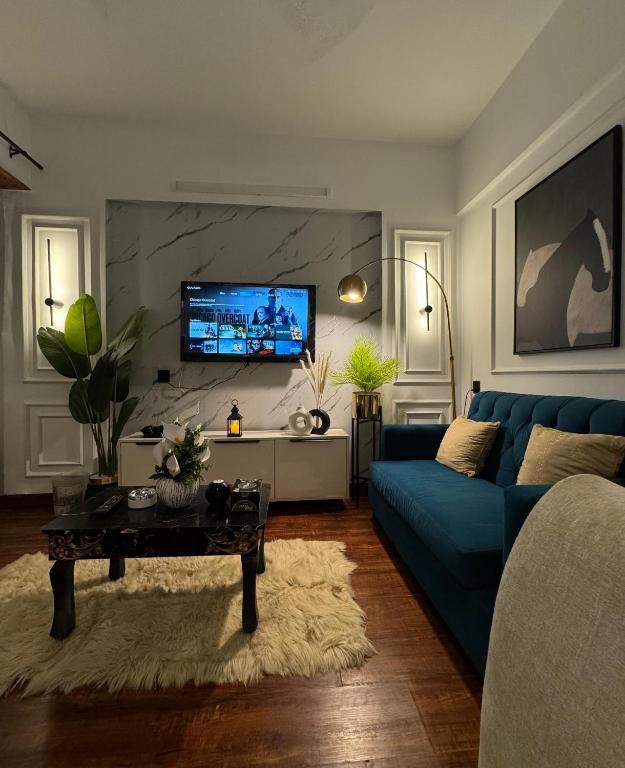 カラチにあるLuxury studio in Dha phase 6の青いソファとテレビのあるリビングルーム