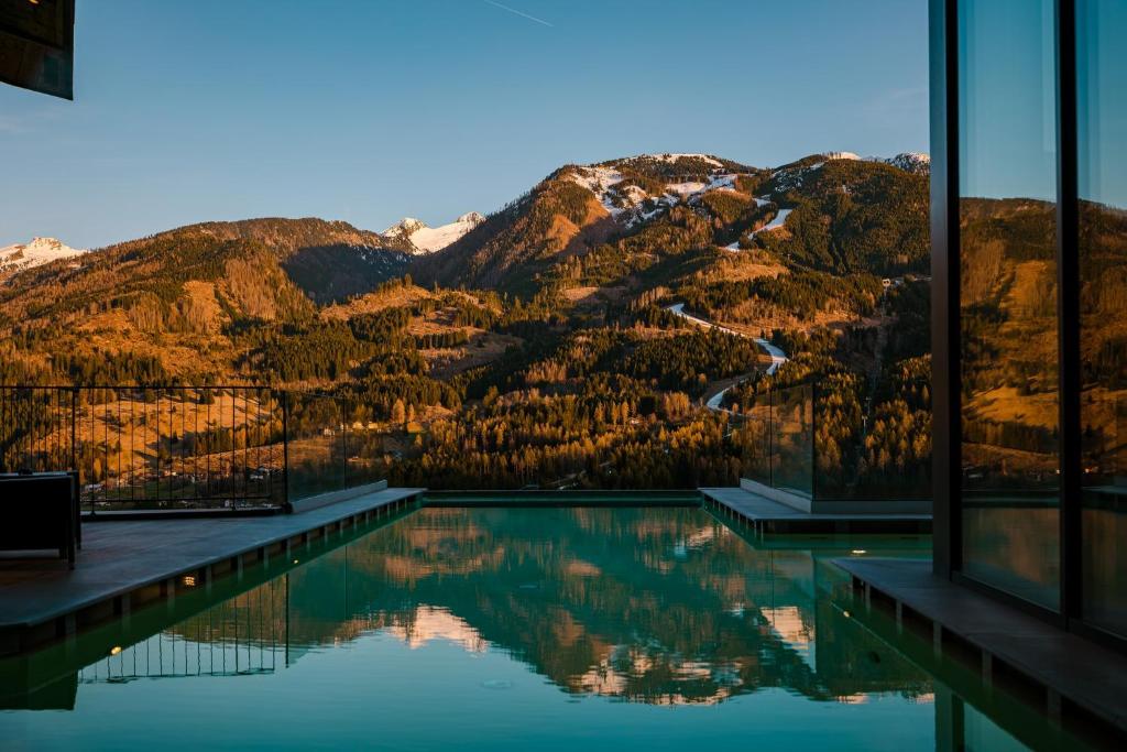 une piscine avec vue sur une montagne dans l'établissement La Roccia Wellness Hotel, à Cavalese