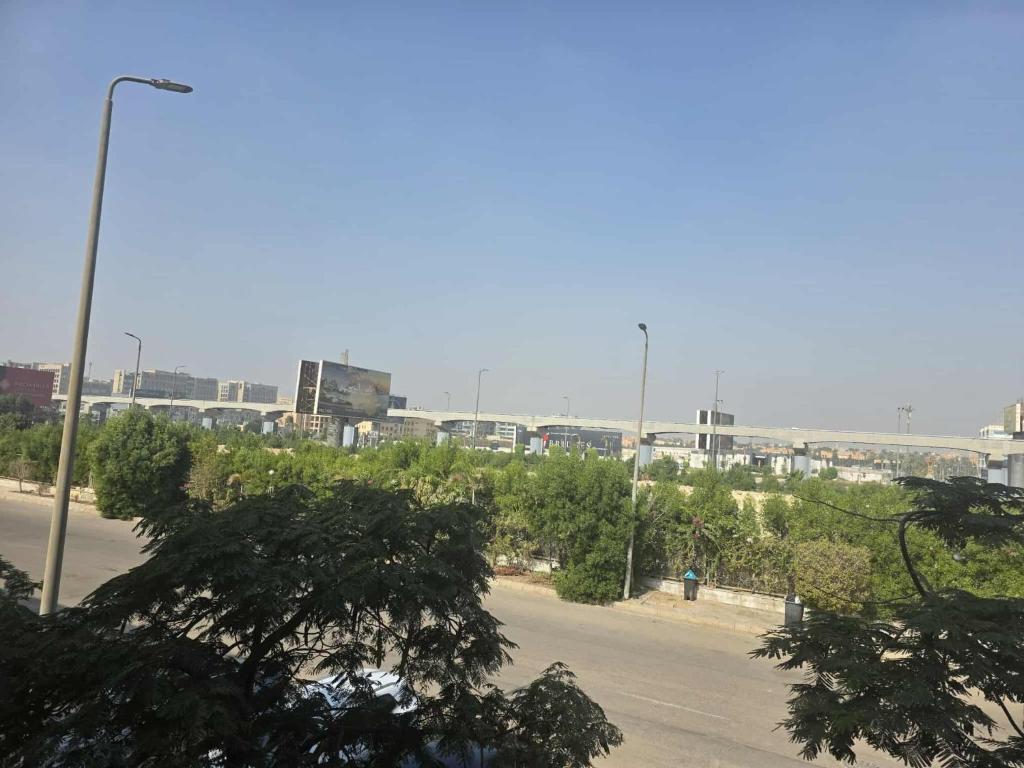 a street with a street light and trees and buildings at وحده فندقيه الخمائل علي المحور واركان بلازا زايد in Cairo
