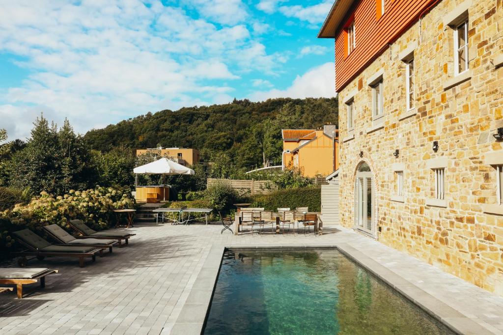 a house with a swimming pool next to a building at Le Chalet du Lac de Warfaaz in Jalhay
