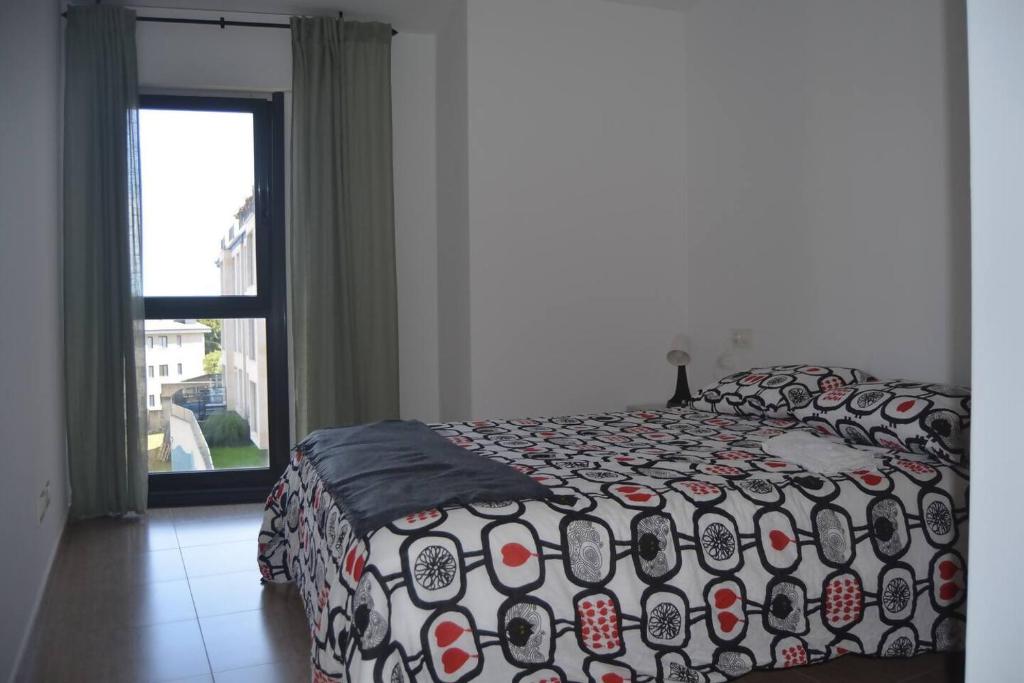 アーレスにあるPrecioso apartamento con garaje en Aresのベッドルーム1室(ベッド1台、掛け布団、窓付)