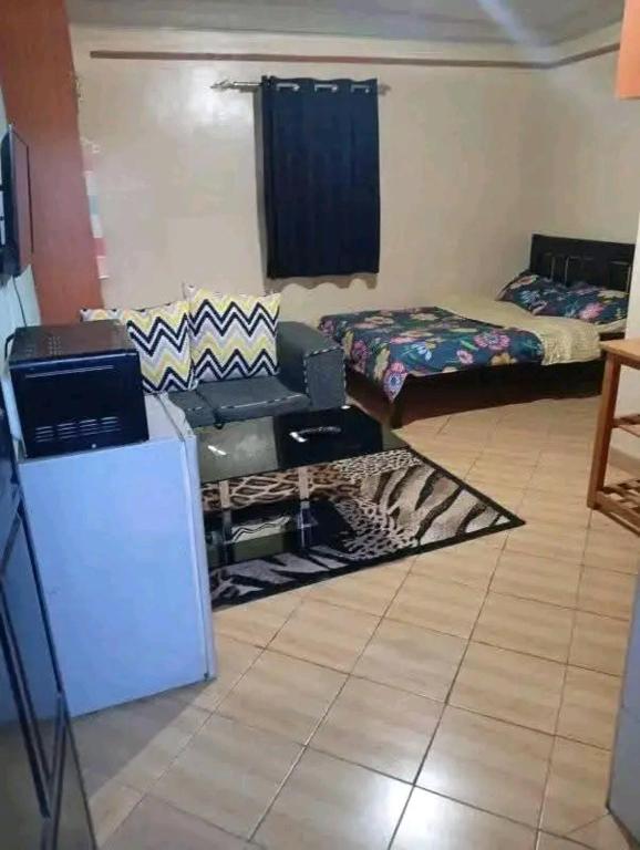 a living room with a room with a couch and a table at Cozy Studio in Rungiri