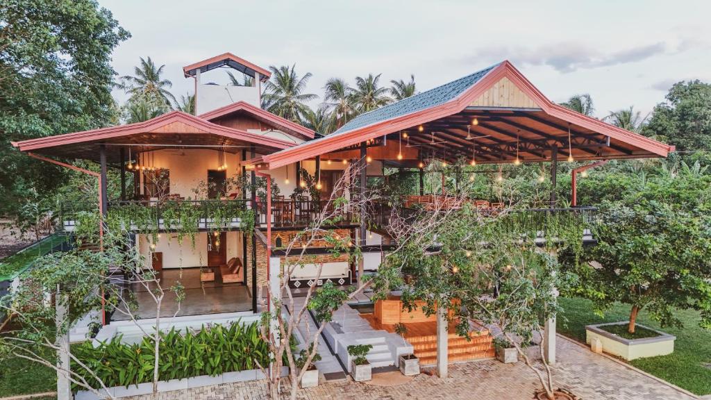 ein Haus mit vielen Bäumen davor in der Unterkunft Ibbankatuwa Lake Resort in Dambulla