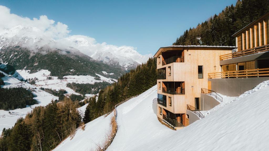 a building on the side of a snow covered mountain at Lahnerhof Chalets in Lutago