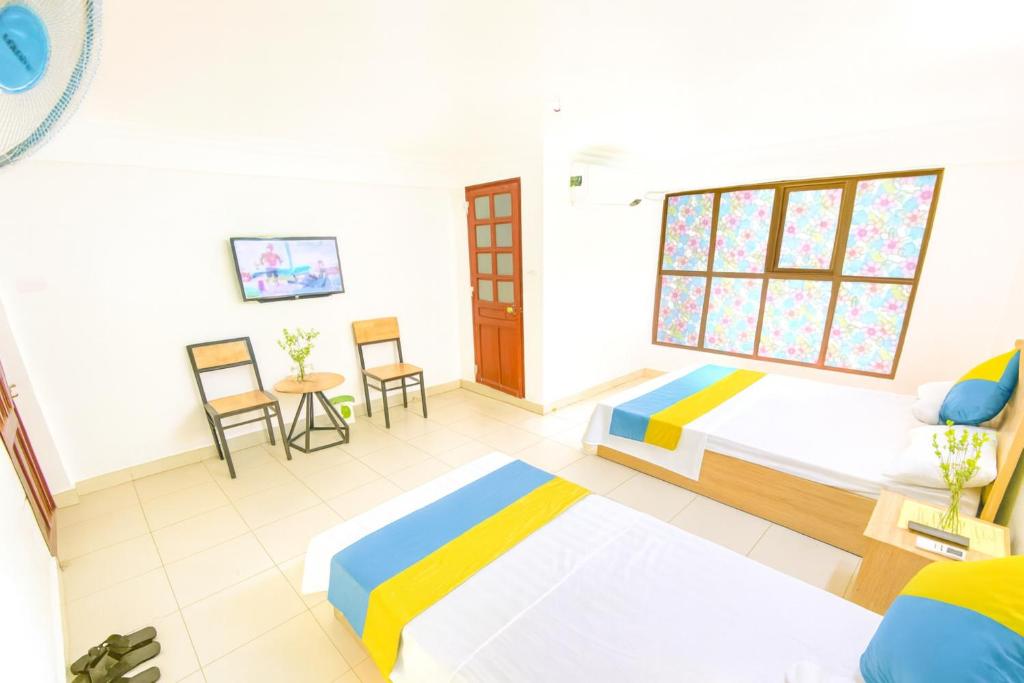 a bedroom with two beds and a table and chairs at Bích Ngọc Hotel Hà Nội in Hanoi