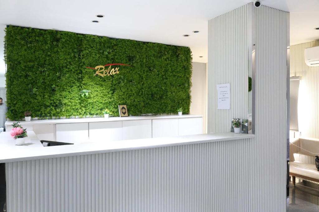 a green wall behind a counter in a room at ريلاكس للاجنحة الفندقية in Amman
