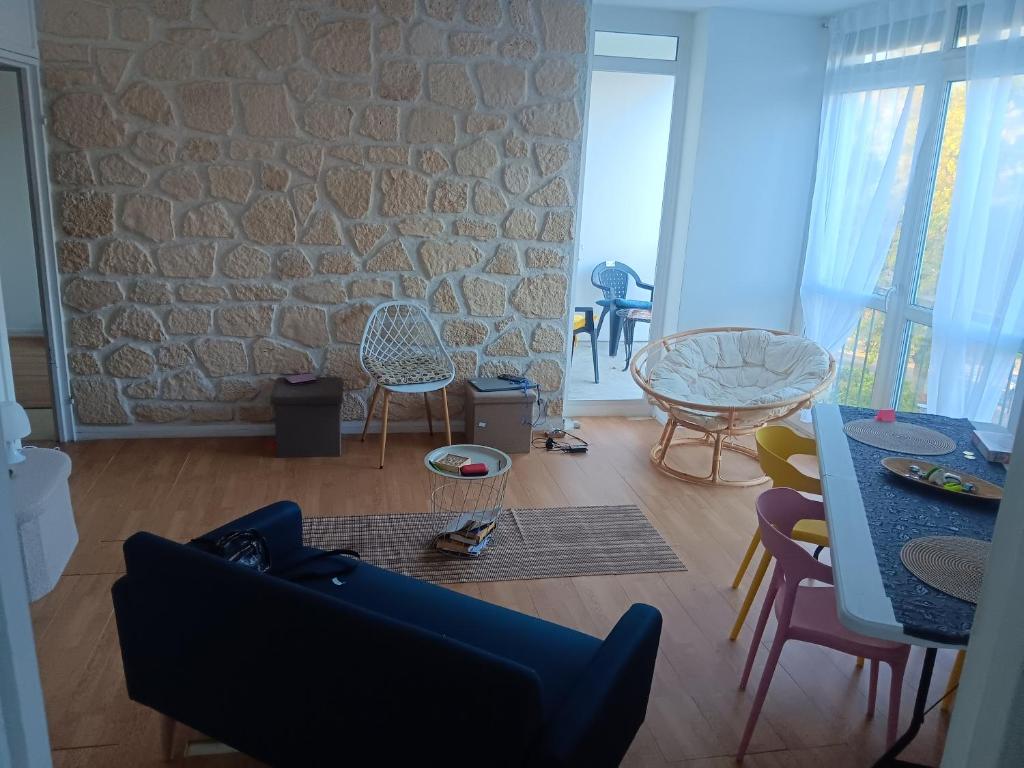a living room with a couch and chairs and a stone wall at Olembe Garden in Avon