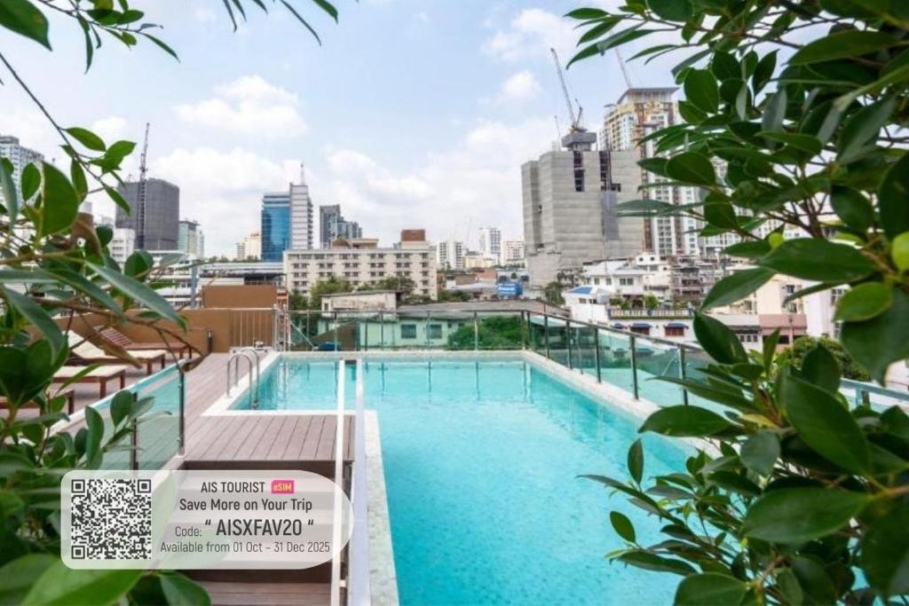バンコクにあるHyde Park Hotel Bangkokの市街のスカイラインを背景にしたスイミングプール