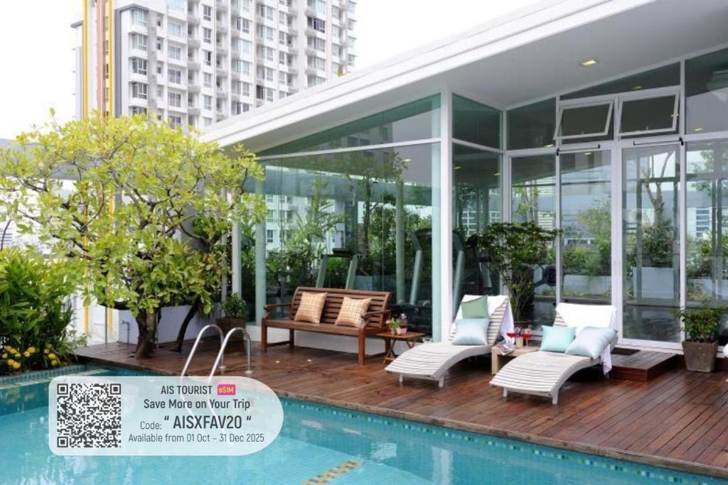 una casa con piscina al lado de un edificio en Sabai Sathorn Service Apartment, en Bangkok