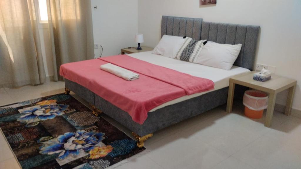 a bedroom with a large bed with a red blanket at Bait Alhoor in Muscat
