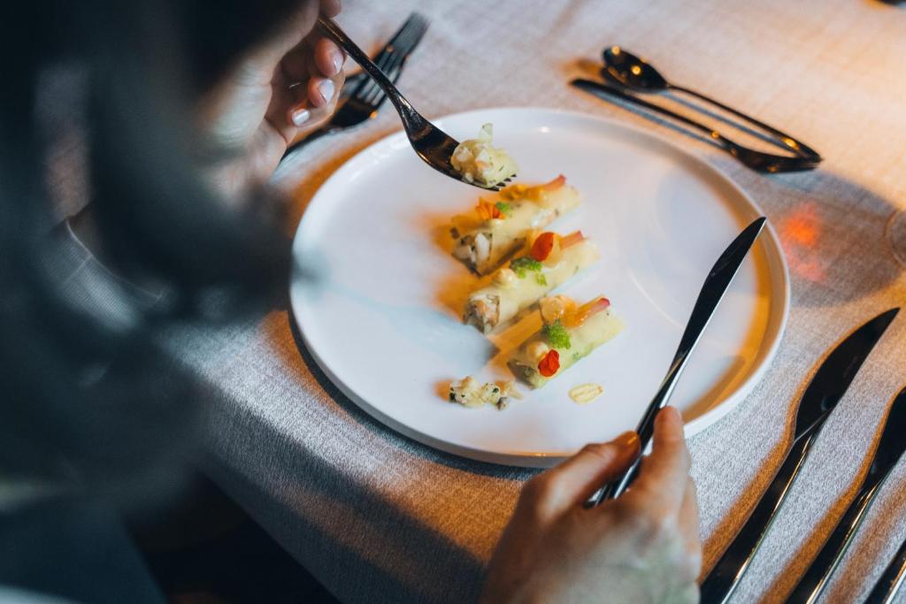 una persona che mangia un piatto di cibo su un tavolo di Boutique Hotel Mandarfnerhof a Sankt Leonhard im Pitztal