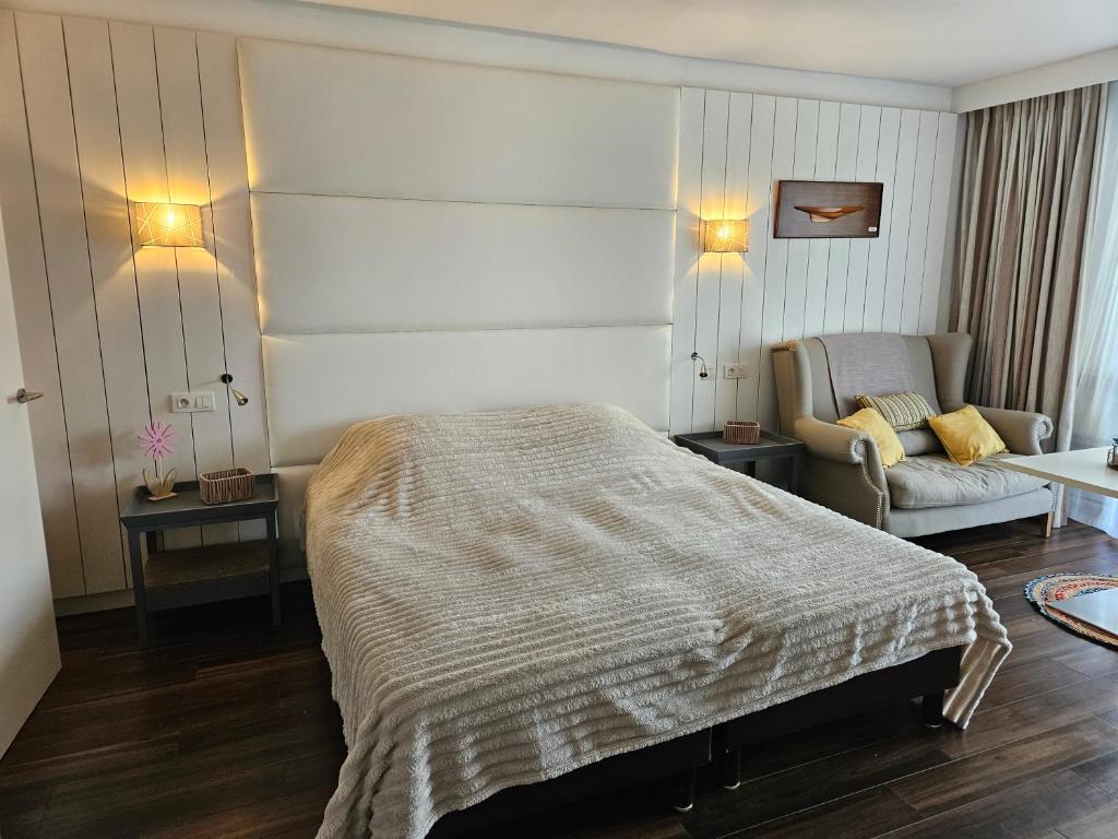 アングレットにあるRésidence Chiberta Anglet océan golf surfのベッドと椅子のある寝室