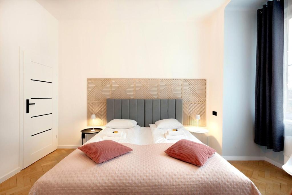 a bedroom with a large bed with two pillows at Roomy apartment Łobzowska Street in Kraków