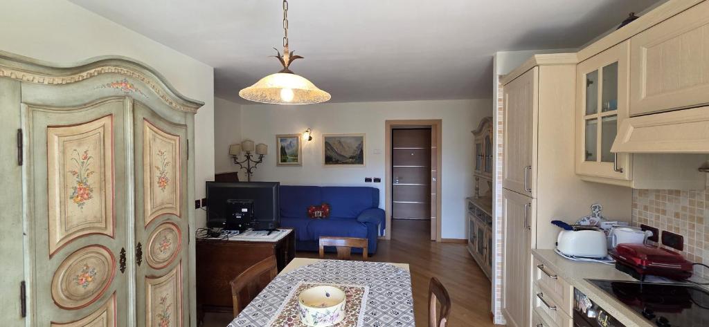 a kitchen with a table and a blue couch at Casa Aloch da Aldo Gianni in Pozza di Fassa