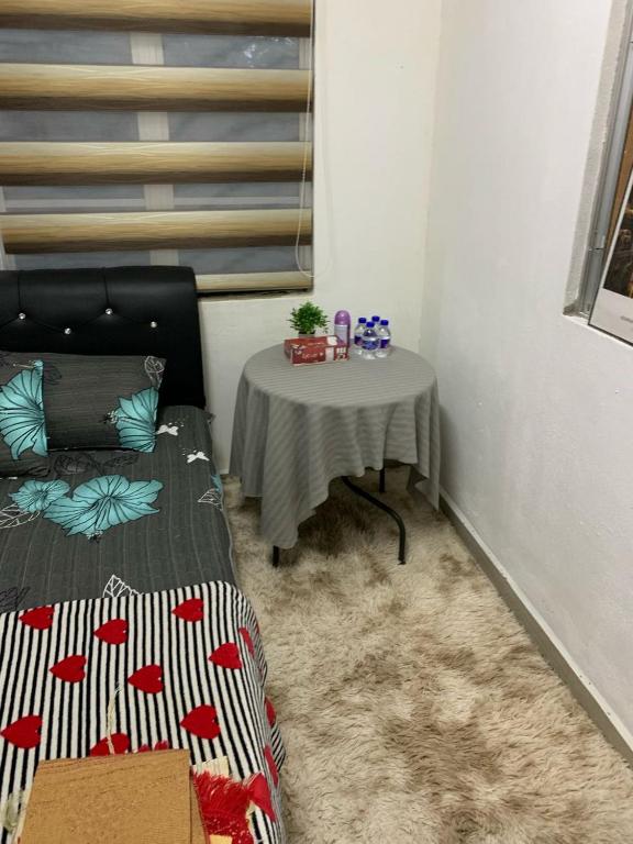 a room with a table and a bed and a table with a table at Aydan Homestay in Kampong Bagan