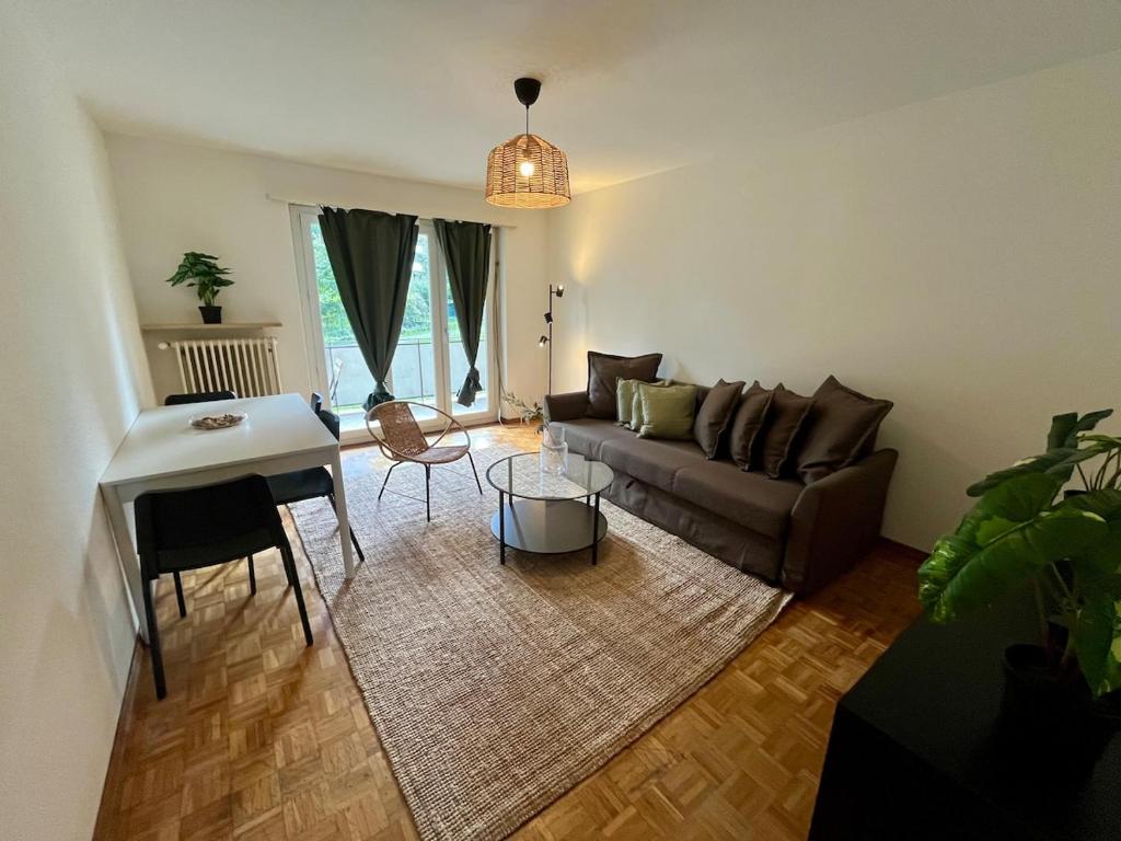 un soggiorno con un divano e un tavolo di Basic & Comfy on Langgrütstrasse a Zurigo