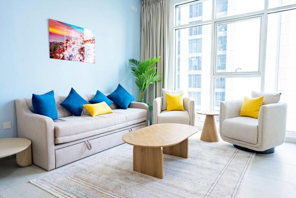 een woonkamer met een bank, twee stoelen en een tafel bij Sustainable Luxury 1BR Reem Island Stay 4 Guest in Abu Dhabi