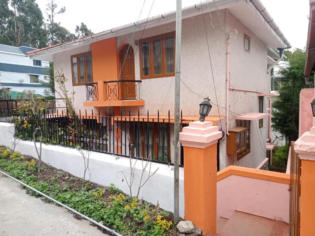a house with an orange and white at Kodai ARYASREE in Kodaikānāl